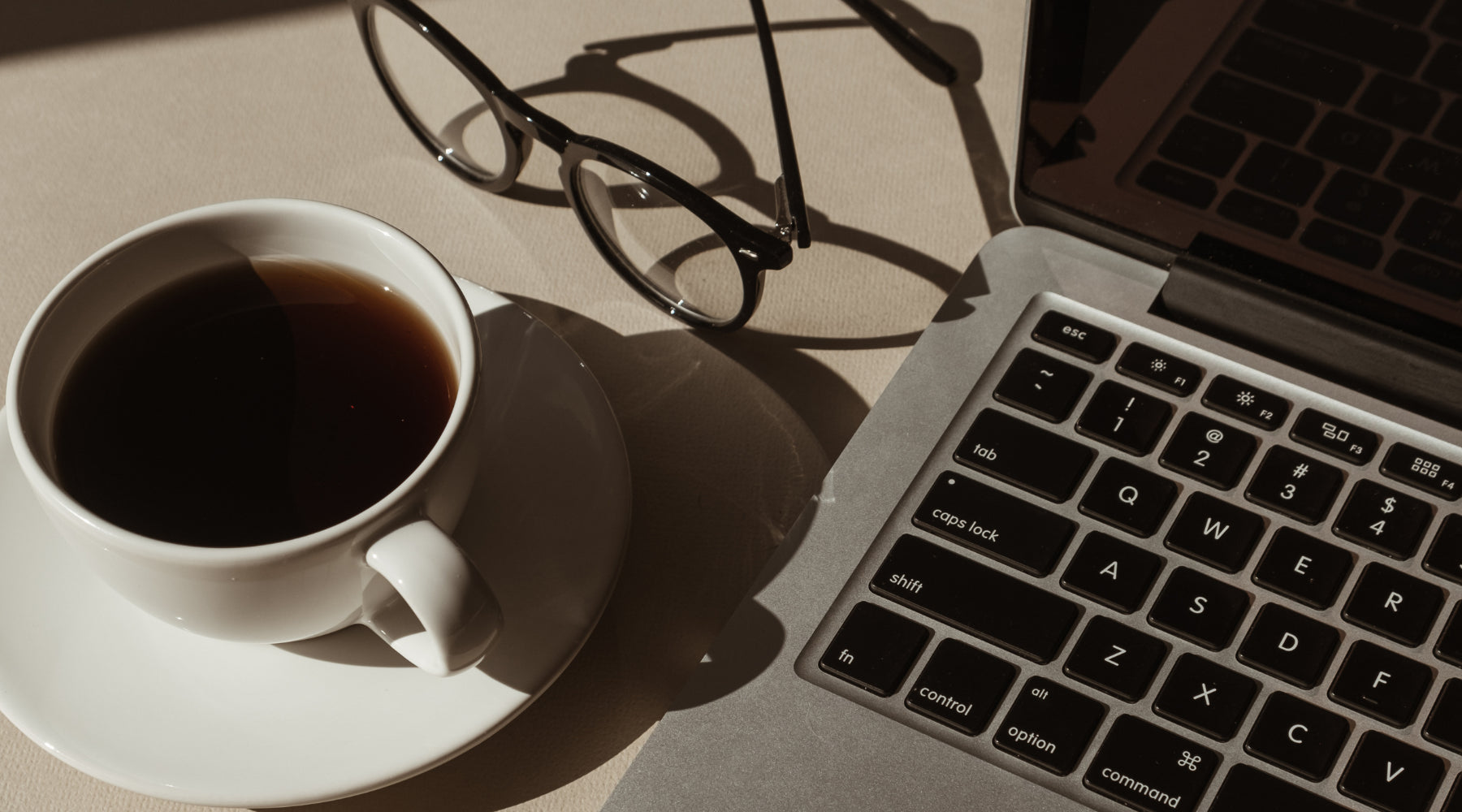 A woman sitting with her laptop in warm daylight